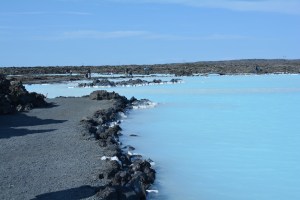O contraste do azul claro da água com o solo vulcânico é impressionante